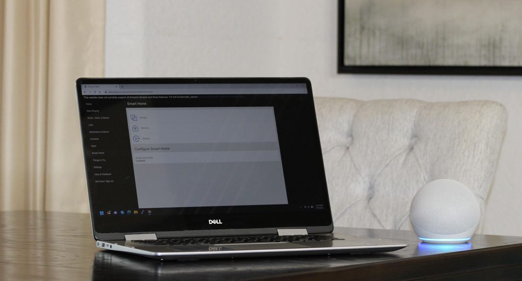A laptop with the Alexa smart home dashboard web interface and an Alexa Echo Dot