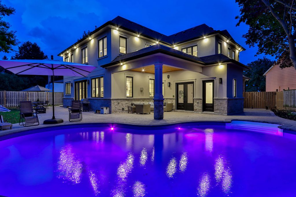 Image of backyard with swimming pool and exterior lighting